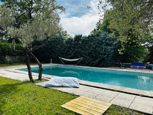 - une piscine dans une cour avec un hamac à côté dans l'établissement La Magadorelle - Villa Spacieuse - 5 chb & Piscine, à Brignoles