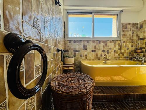 a bathroom with a yellow tub and a sink at La Magadorelle - Villa Spacieuse - 5 chb & Piscine in Brignoles