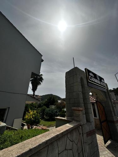 a building with a sign on it next to a wall at Carmina Hotel in Ovacik