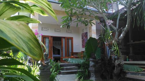 a house with a bunch of plants in front of it at Suryadina Guest House in Ubud