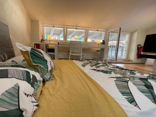 una camera con un grande letto e una scrivania di Loft-House - Maison Vigneronne Village UNESCO a Rivaz