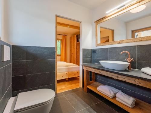 a bathroom with a sink and a toilet and a mirror at AlmApARTment Mauterndorf Pichl 9-3 in Mauterndorf