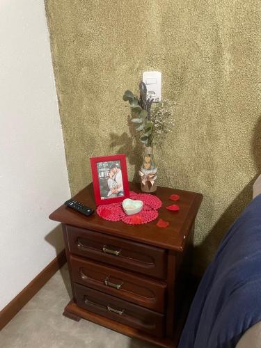 a table with a picture on top of a bed at Casa Aconchegante na Montanha in Campos do Jordão