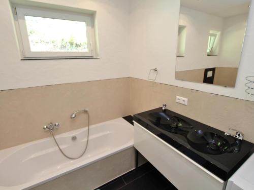 a bathroom with a black sink and a bath tub at Apartment Franz in Sattendorf