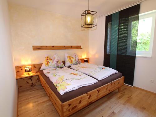 a bedroom with a wooden bed with white sheets at Apartment Franz in Sattendorf