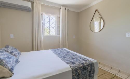 a bedroom with a bed and a mirror at Casa temporada Condomínio Clube, até 10 pessoas. in Caldas Novas