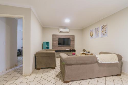 a living room with two couches and a tv at Casa temporada Condomínio Clube, até 10 pessoas. in Caldas Novas