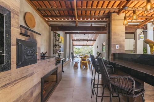 a dining room with a bar with chairs at Casa temporada Condomínio Clube, até 10 pessoas. in Caldas Novas