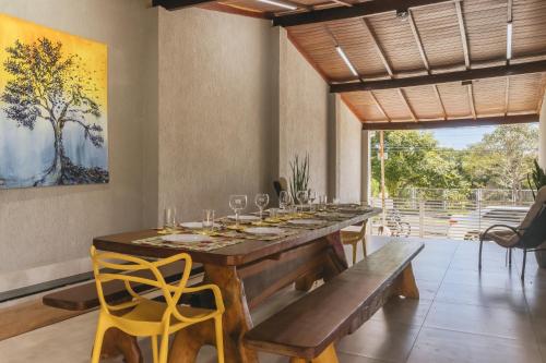 a dining room with a long table with wine glasses at Casa temporada Condomínio Clube, até 10 pessoas. in Caldas Novas