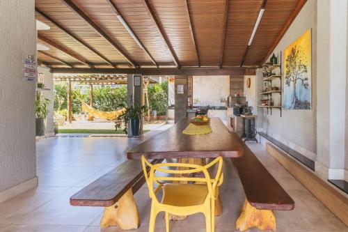 a dining room with a wooden table and yellow chairs at Casa temporada Condomínio Clube, até 10 pessoas. in Caldas Novas