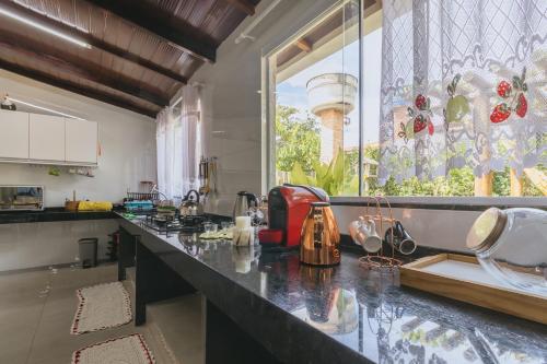 a kitchen with a counter and a large window at Casa temporada Condomínio Clube, até 10 pessoas. in Caldas Novas