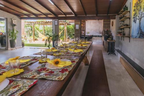 a long wooden table with yellow napkins and glasses at Casa temporada Condomínio Clube, até 10 pessoas. in Caldas Novas