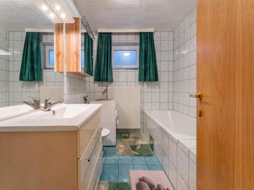 ein Badezimmer mit zwei Waschbecken, einer Badewanne und einem WC in der Unterkunft Schmitzer in Mühldorf