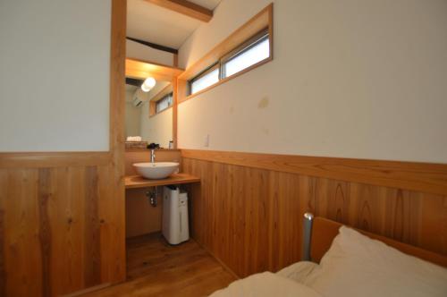 een kleine badkamer met een wastafel en een wastafel bij Guest House Ilonggo in Tsu