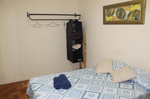 Un dormitorio con una cama con una toalla. en Anfitrioca Apartamento Gloria, en Río de Janeiro