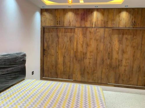 a bedroom with a large wooden wall next to a bed at Dar Fatouma - Tazarka in Tazarka