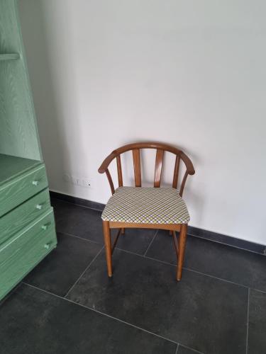 una silla de madera en la esquina de una habitación en Sunbath House Pisa - Free Parking - Near Pisa Center, en Pisa