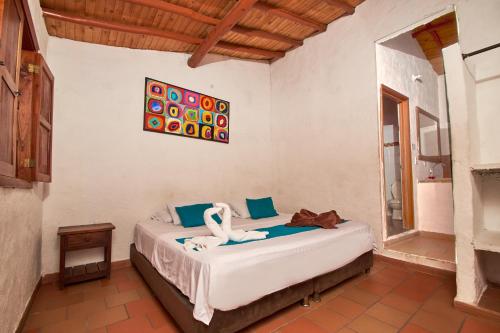 Un dormitorio con una cama con cisnes. en Hotel Terrazas de la Candelaria, en San Gil