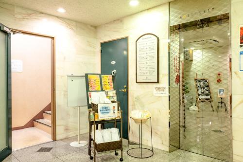 um quarto com um chuveiro e uma porta de vidro em Plaza Hotel Nogata em Nōgata