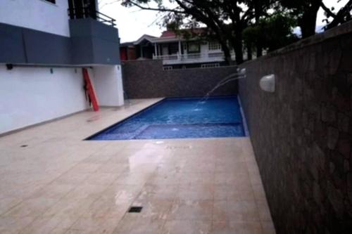 une piscine avec un tuyau fixé à un mur dans l'établissement Apartamento en Villavicencio, à Villavicencio