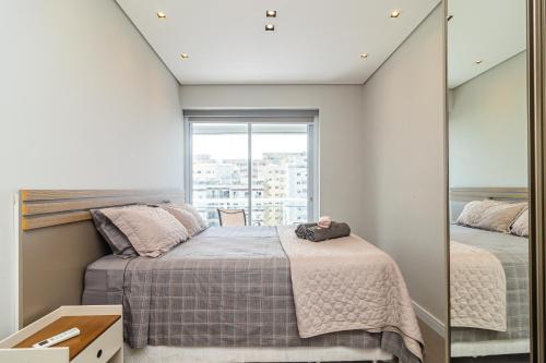 a bedroom with a bed and a mirror at AP OCEAN UNLIMITED - Vista panorâmica da praia de Santos no Unlimited in Santos