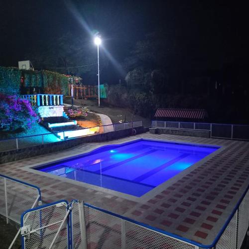 a swimming pool at night with blue lights at Chalet Villa Alejandra Del Pilar in Quimbaya