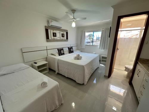 1 Schlafzimmer mit 2 Betten und einem Fenster in der Unterkunft Flat em Condomínio Mont Sião in Porto Seguro