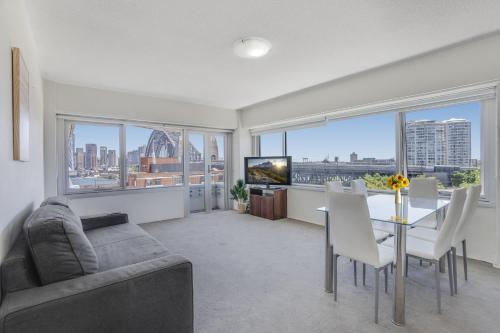 een woonkamer met een bank en een tafel met stoelen bij Sydney Harbour View Apartments in Sydney