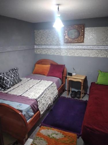 een slaapkamer met 2 aparte bedden en een tafel bij studio toufik in Taza