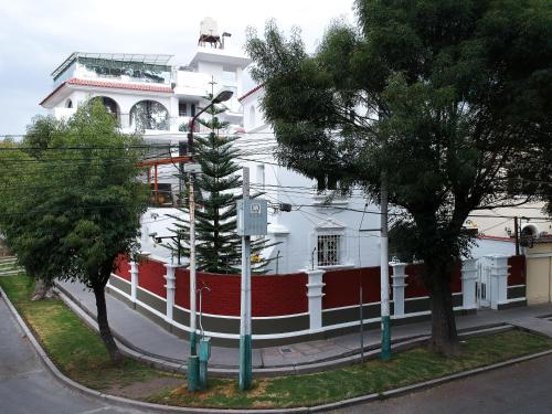 a white building with a red and white fence at Suite Picchu Picchu in Arequipa