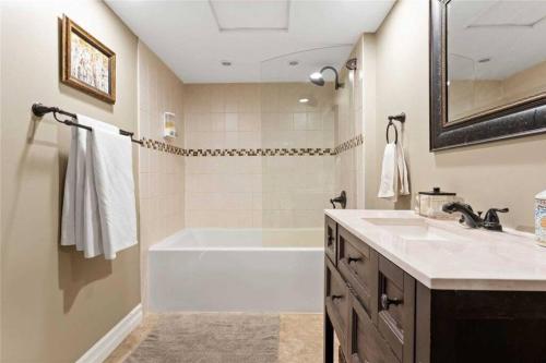 a bathroom with a white tub and a sink at Perfection near the River - 4 Bedroom Villa Complimentary Breakfast Delivered Daily to the Rental in Niagara Falls