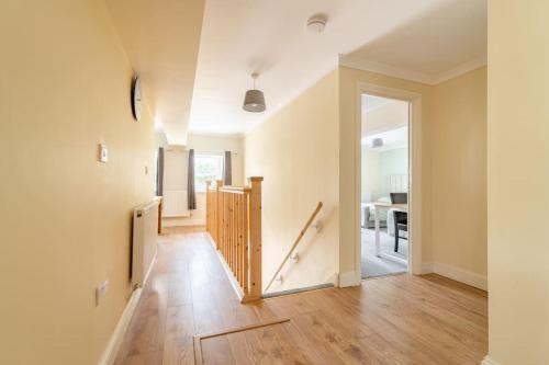 una sala de estar vacía con suelo de madera y pasillo en The Blue House holiday home en Egremont