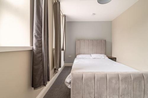 Un dormitorio con una cama grande y una ventana en The Blue House holiday home en Egremont