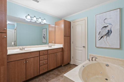 łazienka z wanną i obrazem ptaka na ścianie w obiekcie The Oasis By Liquid Life w mieście Orange Beach