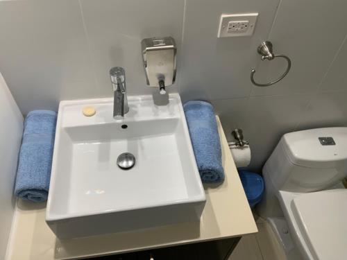 a bathroom with a white sink and a toilet at Cómodo Apartamento con vista al Mar y piscina in María Chiquita