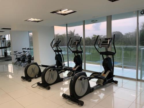 a row of exercise bikes in a room with windows at Cómodo Apartamento con vista al Mar y piscina in María Chiquita