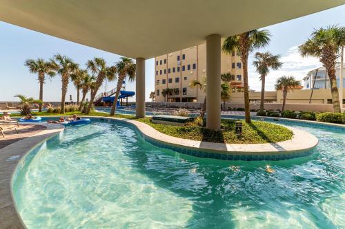 - une piscine dans un complexe avec des palmiers dans l'établissement The Oasis By Liquid Life, à Orange Beach