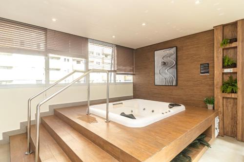 a bath tub in a room with wooden walls at AP OCEAN UNLIMITED - Vista panorâmica da praia de Santos no Unlimited in Santos