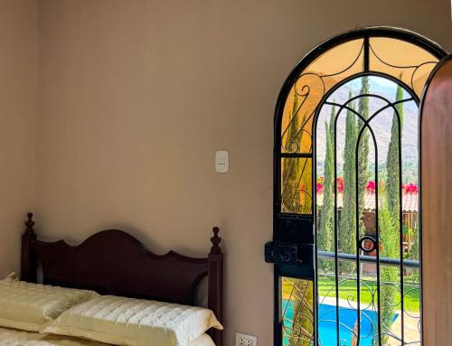 a bedroom with a bed and a stained glass window at Casa Hotel Mamaluna in Lunahuaná