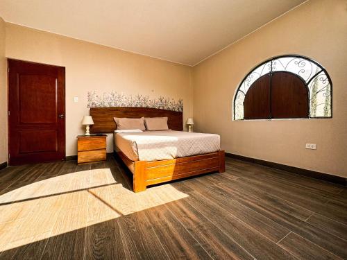 1 dormitorio con cama y ventana abovedada en Casa Hotel Mamaluna, en Lunahuaná