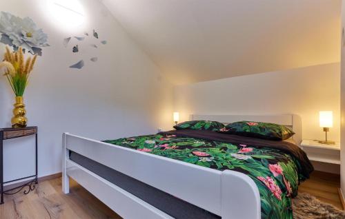 a bedroom with a white bed with a green and pink blanket at Amazing Home In Donja Lomnica With Kitchen in Donja Lomnica