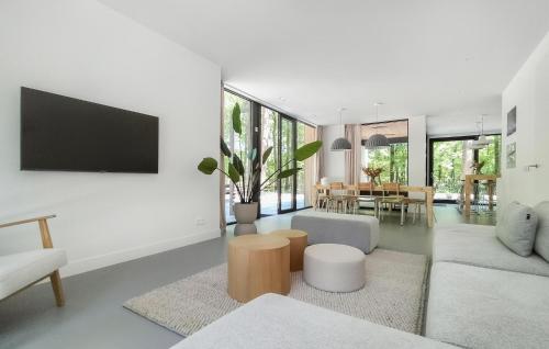 a living room with a couch and a tv on a wall at Lovely Home In Bennekom With Sauna in Bennekom