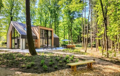a small cabin in the woods with a bench at Lovely Home In Bennekom With Sauna in Bennekom