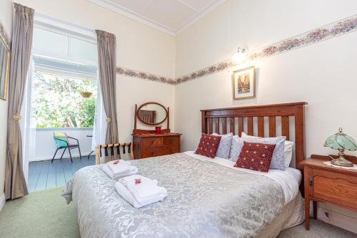 1 dormitorio con 1 cama con 2 toallas en Braemar House B&B and YHA Hostel en Whanganui