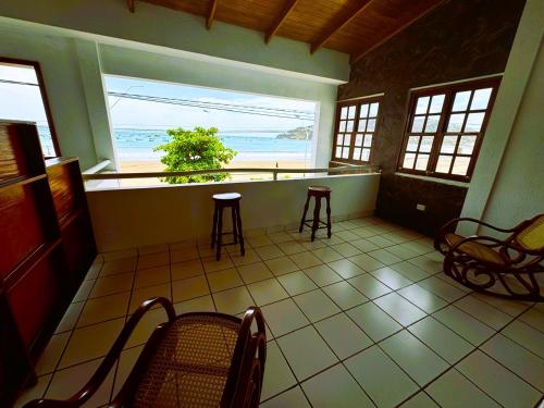 a room with chairs and a view of the ocean at Hotel Ocean View in San Juan del Sur