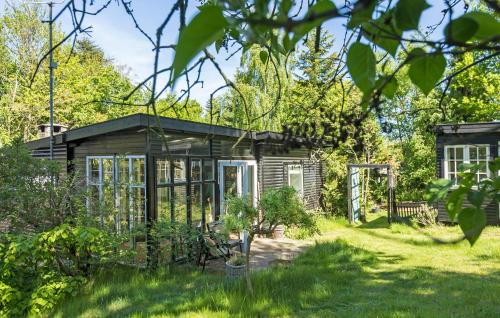 a small greenhouse in the garden of a house at Pet Friendly Home In Melby With Wifi in Melby