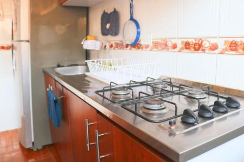 a kitchen with a stove top in a kitchen at Acogedor Apartamento en zona residencial con vista a la ciudad Wi-Fi 350 Mbps in Bogotá