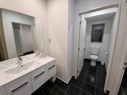 a bathroom with a white sink and a toilet at Home away from home in Rolleston in Rolleston