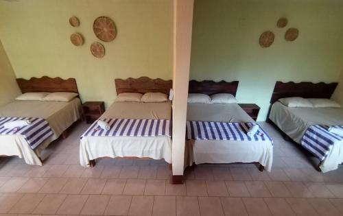Hotel Israel في Guastatoya: غرفة بثلاث اسرة في غرفة