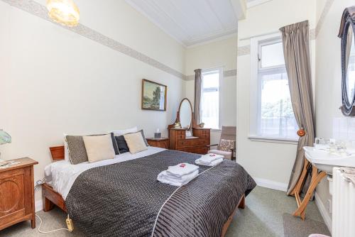 a bedroom with a bed and a sink at Braemar House B&B and YHA Hostel in Whanganui